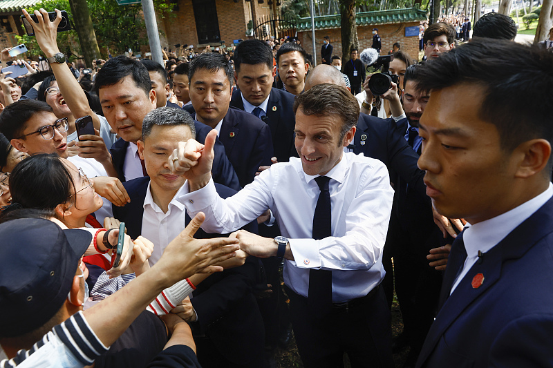 French President Emmanuel Macron (C) is welcomed by students at Sun Yat-sen University, Guangzhou City, southern China's Guangdong Province, April 7, 2023. /CFP