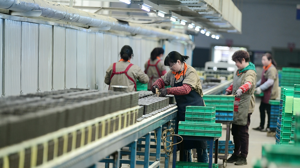 Workers are clutching the production of magnetic core products in a workshop in Hai'an City, Jiangsu Province on March 6, 2023./CFP