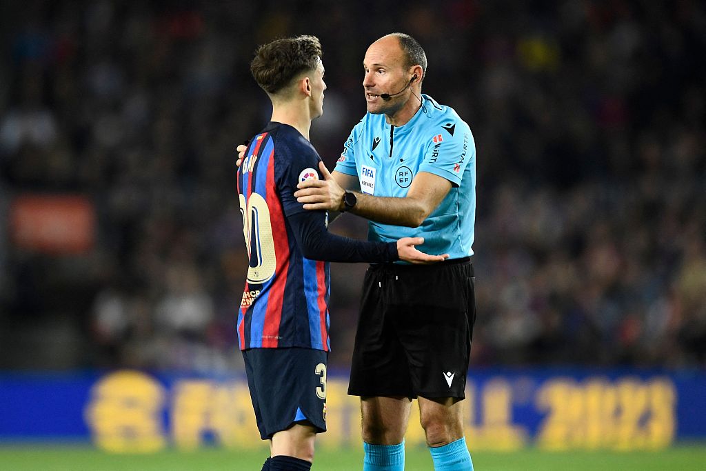 Spanish referee Mateu Lahoz talks with Barcelona's Spanish midfielder Gavi (L) during the match at the Camp Nou Stadium in Barcelona, Spain, April 10, 2023. /CFP