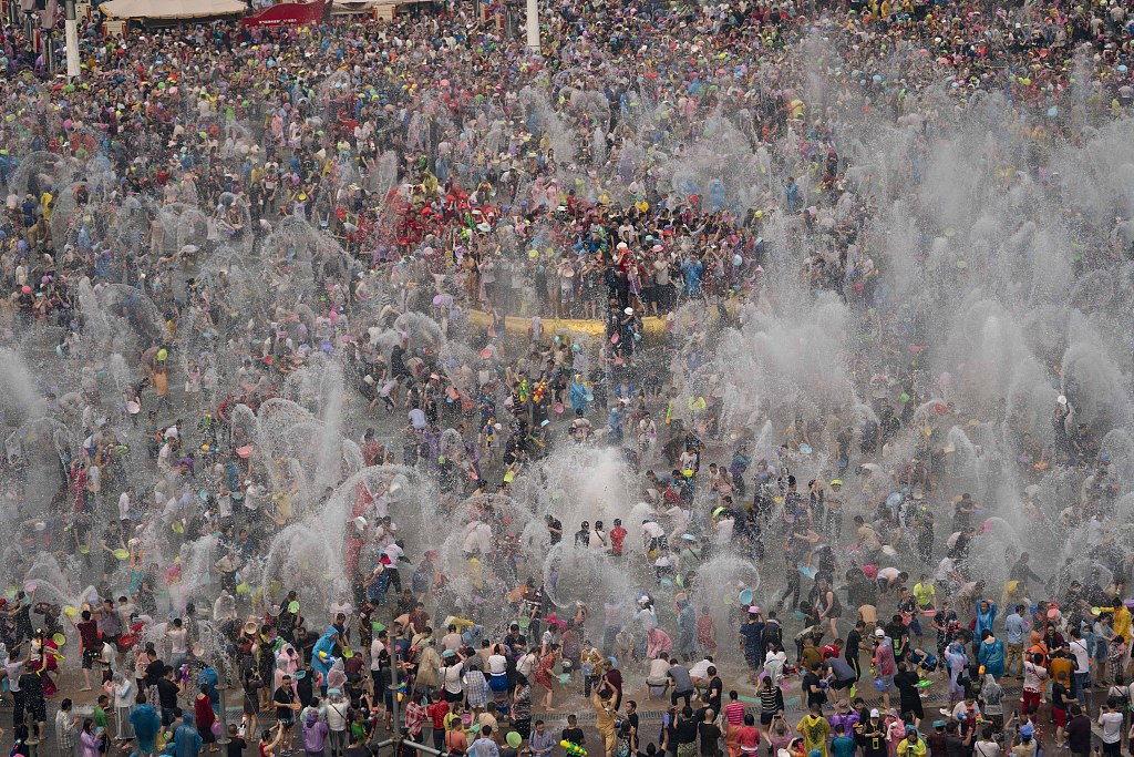 Tens of thousands of Dai people and tourists enjoy the Water Splashing Festival at a square in Xishuangbanna, Yunnan. /CFP