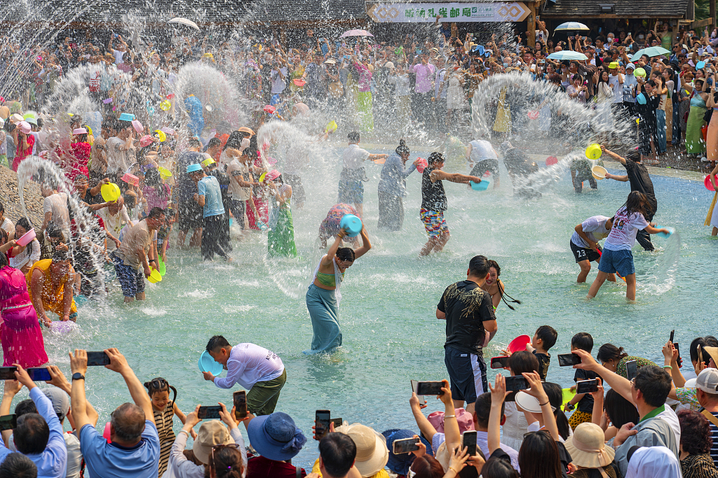 Tourists enjoy splashing water at an ethnic Dai scenic spot in Kunming, Yunnan. /CFP