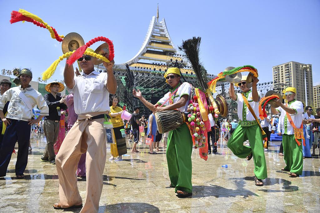 Dai people dance while playing their traditional instruments during the Water Splashing Festival in Dehong Prefecture, Yunnan. /CFP