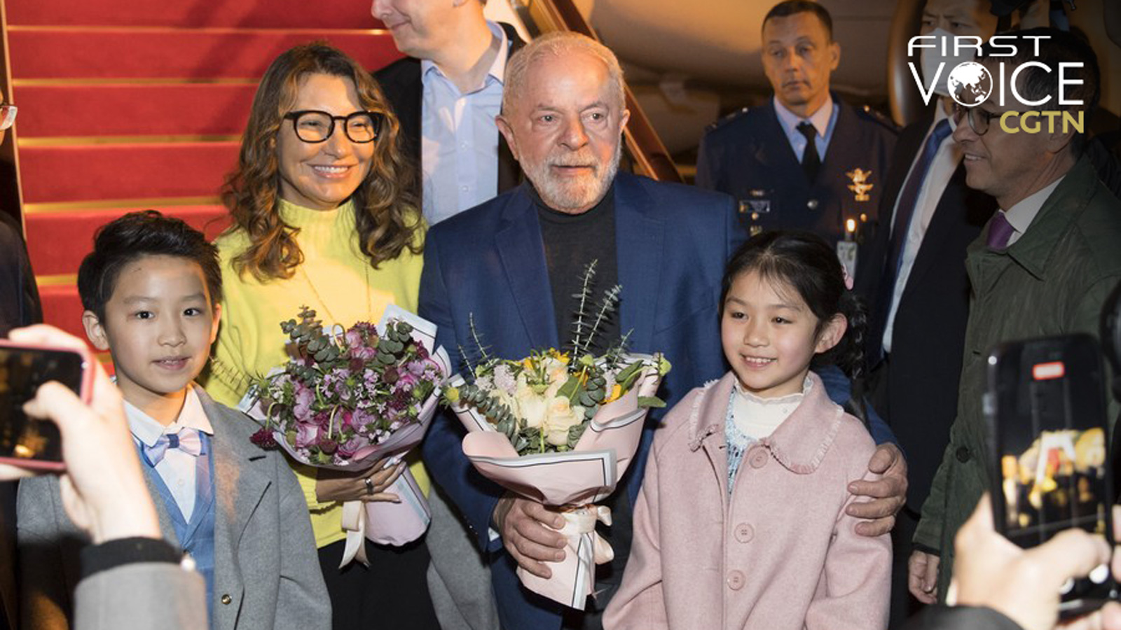 Brazilian President Luiz Inacio Lula da Silva and his wife receive flowers presented by children from the Shanghai Children's Palace of the China Welfare Institute and pose for a photo with them upon arrival in Shanghai, east China, April 12, 2023. /Xinhua