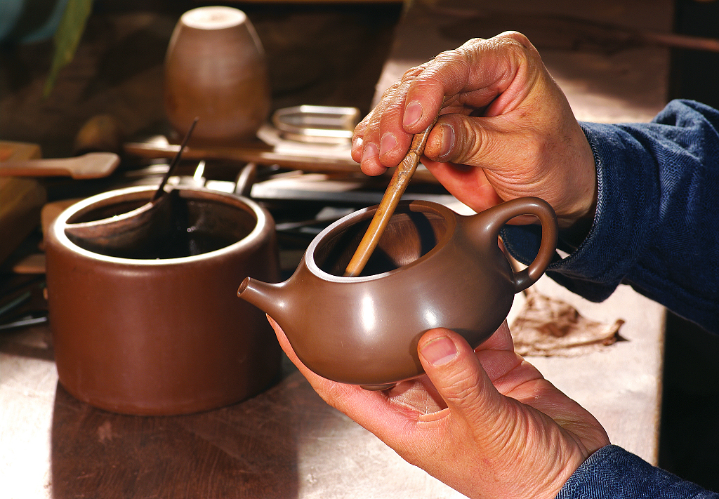 A file photo shows the molding of a purple clay teapot. /CFP