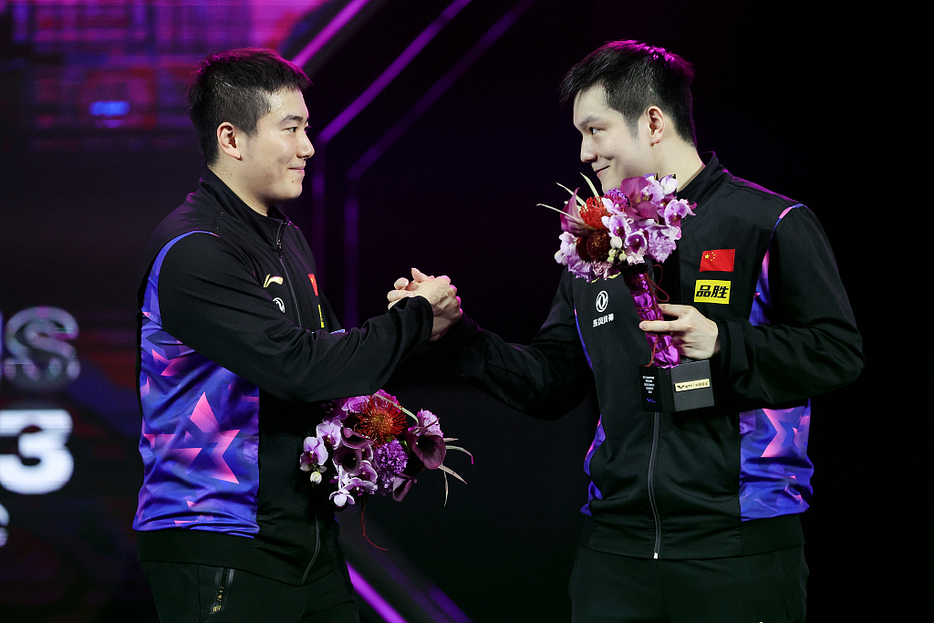 China's Fan Zhendong (R) shakes hands with Liang Jingkun after their men's singles final during the WTT Champions event in Xinxiang, China, April 15, 2023. /CFP
