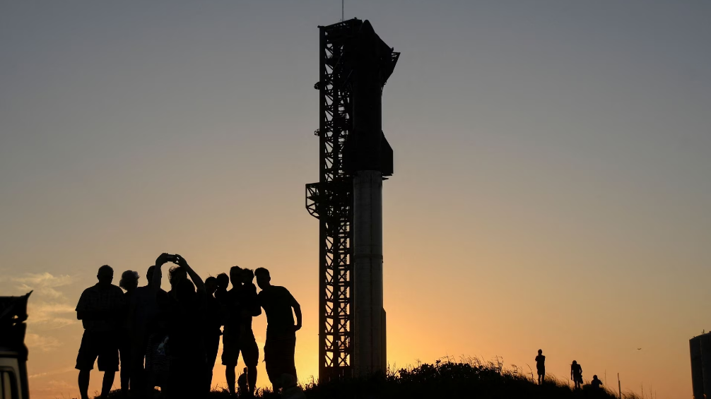 Tourists take photos at sunset of SpaceX's Starship the day before it launches from the Starbase launchpad on an orbital test mission, in Boca Chica, Texas, U.S., April 16, 2023. /Reuters