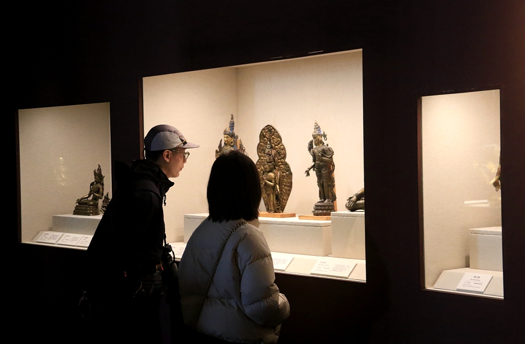 Tourists visit an exhibition where 120 pieces (sets) of precious cultural relics from China's Dunhuang Research Academy's collection are on display in Dunhuang, northwest China's Gansu, on April 14, 2023. /CFP