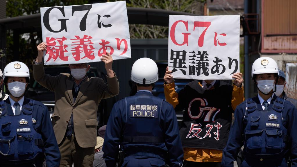 Protesters holding placards are pictured near the Karuizawa station of shinkansen train in Nagano Prefecture, Japan, April 16, 2023. /Xinhua