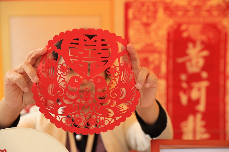 An artisan shows off her paper-cutting artworks at the Yellow River Fair in Dongying City, Shandong Province. /CFP