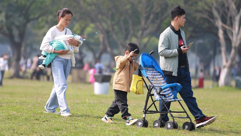 A family spends time together at a park in Haikou, Hainan Province, south China, February 12, 2021. /CFP
