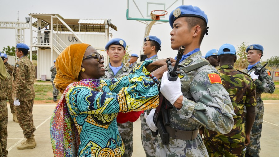 Anita Kiki Gebe, deputy joint special representative of the United Nations-African Union Mission in Darfur (UNAMID), awards UN peace medal to a soldier of the 2nd China Medium Utility Helicopter Unit (CMUHU02) in El-Fashir, Sudan, July 17, 2019. /Xinhua