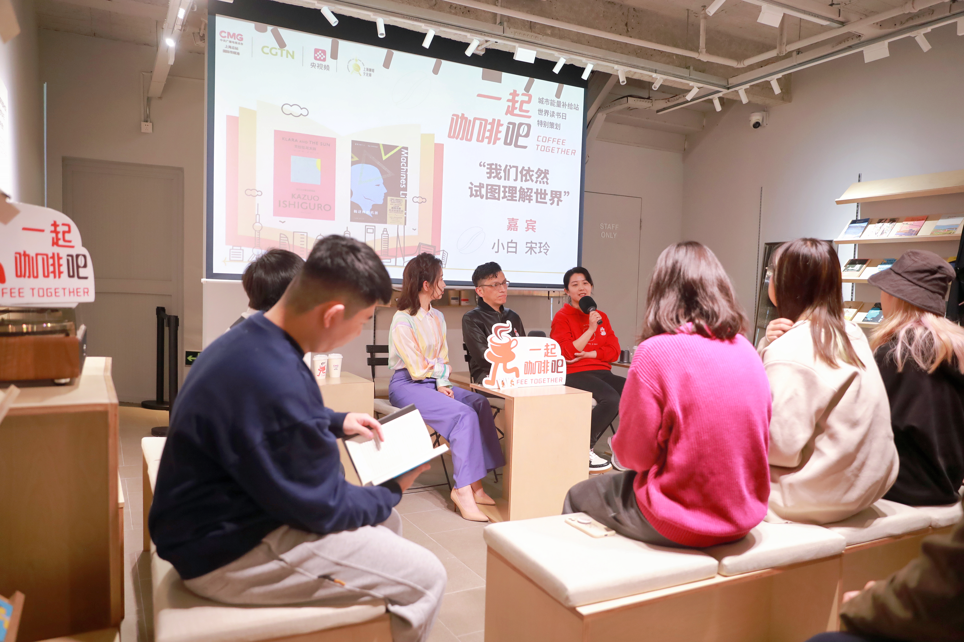 Writer Xiao Bai (center) and editor Song Ling (right) share stories with visitors at a cafe in Shanghai. /CMG