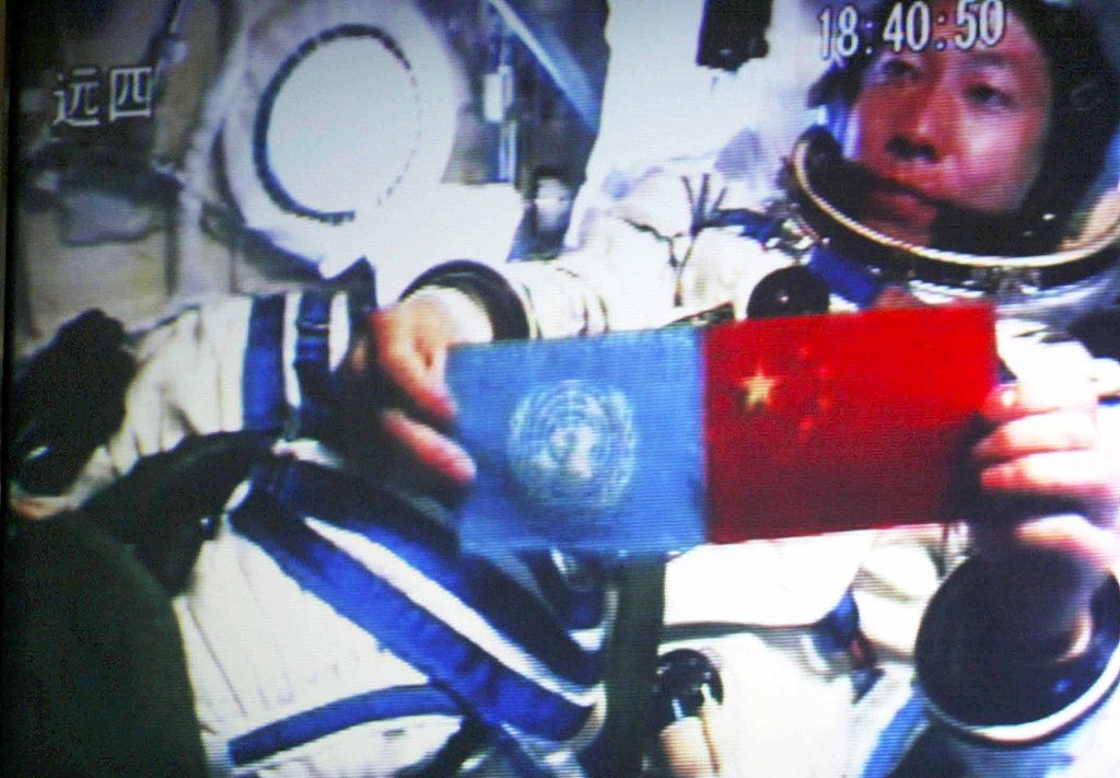 A file photo taken on October 15, 2003, shows Chinese astronaut Yang Liwei aboard the Shenzhou-5 displaying the flags of China and the United Nations. /CFP