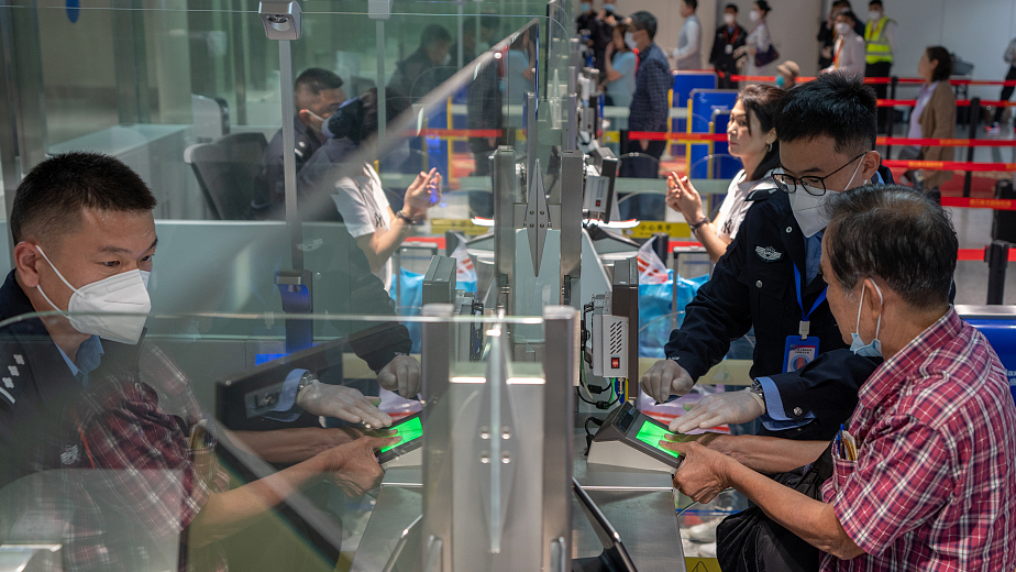 A border control officer helps an inbound passenger apply for visa-free entry procedures at Haikou Meilan International Airport in Haikou, south China's Hainan Province, March 15, 2023. /CFP