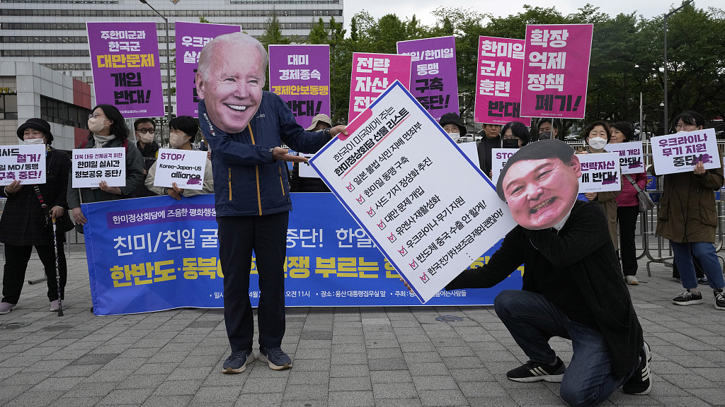 Protesters wearing masks of U.S. President Joe Biden and South Korean President Yoon Suk-yeol (R) perform during a rally to oppose the visit of Yoon to the United States, in front of the presidential office in Seoul, South Korea, April 26, 2023. /CFP