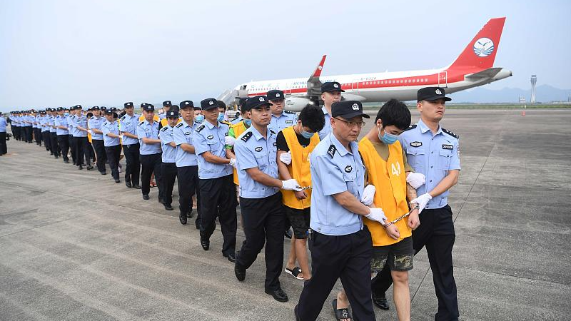 Sixty-three people suspected of cross-border online fraud are escorted back to China from Cambodia through China-Cambodia Law Enforcement Cooperation activities, southwestern China's Chongqing Municipality, June 26, 2019. /CFP