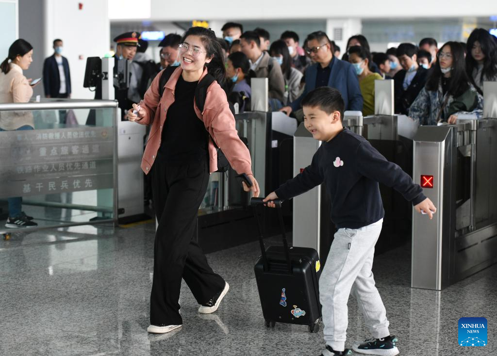 2023 年 4 月 29 日，乘客在中国东部安徽省阜阳市阜阳西站登车前检查车票。/新华社