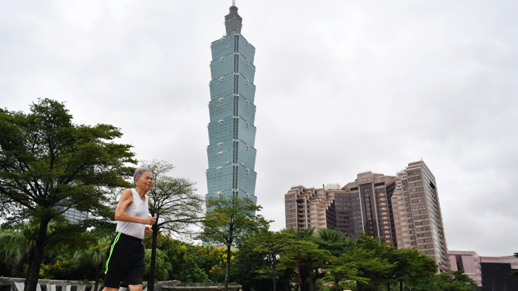A citizen runs in front of the Taipei 101 skyscraper in Taipei, southeast China's Taiwan, October 1, 2019. /Xinhua