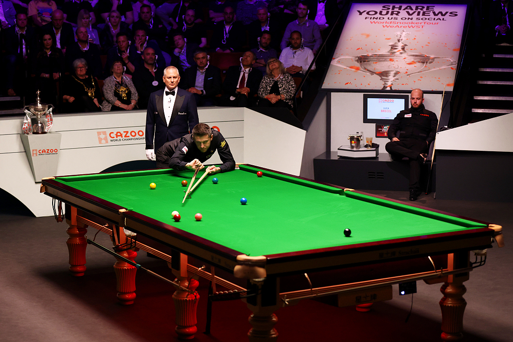 Mark Selby of England plays a shot as Luca Brecel of Belgium looks on during the final of the World Snooker Championship at the Crucible Theatre in Sheffield, England, May 1, 2023. /CFP