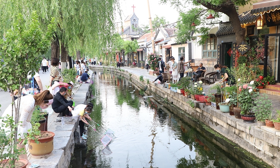 Tourists stroll through the Baihuazhou historical and cultural block in Jinan, Shandong on May 2, 2023. /CFP