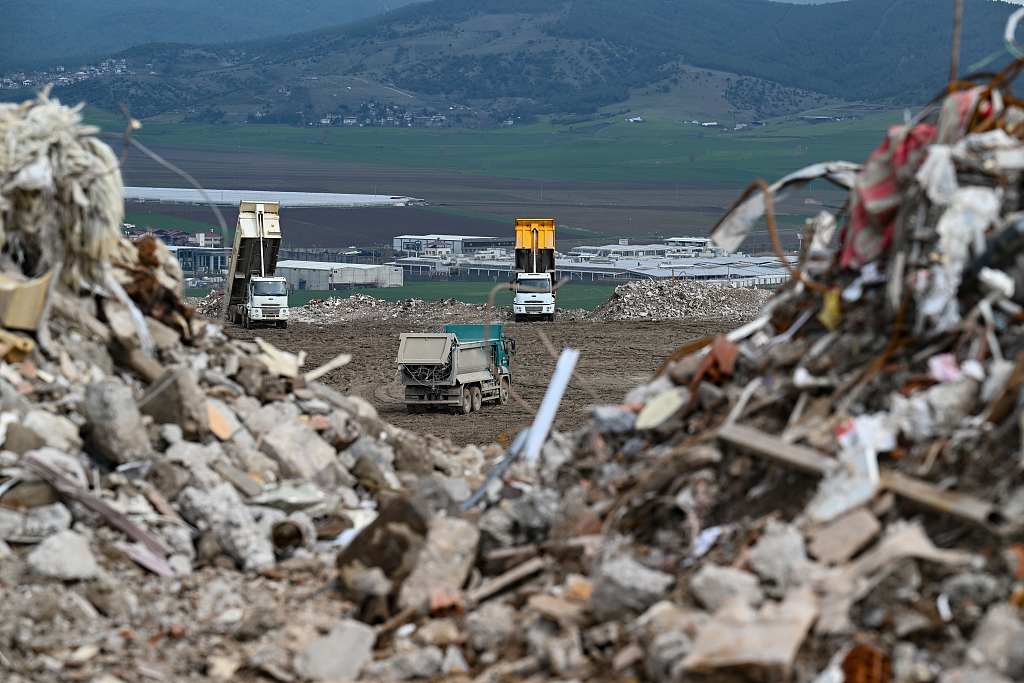Trucks unload rubbles from debris of buildings destroyed after devastating earthquakes in Kahramanmaras, Türkiye, March 20, 2023. /CFP