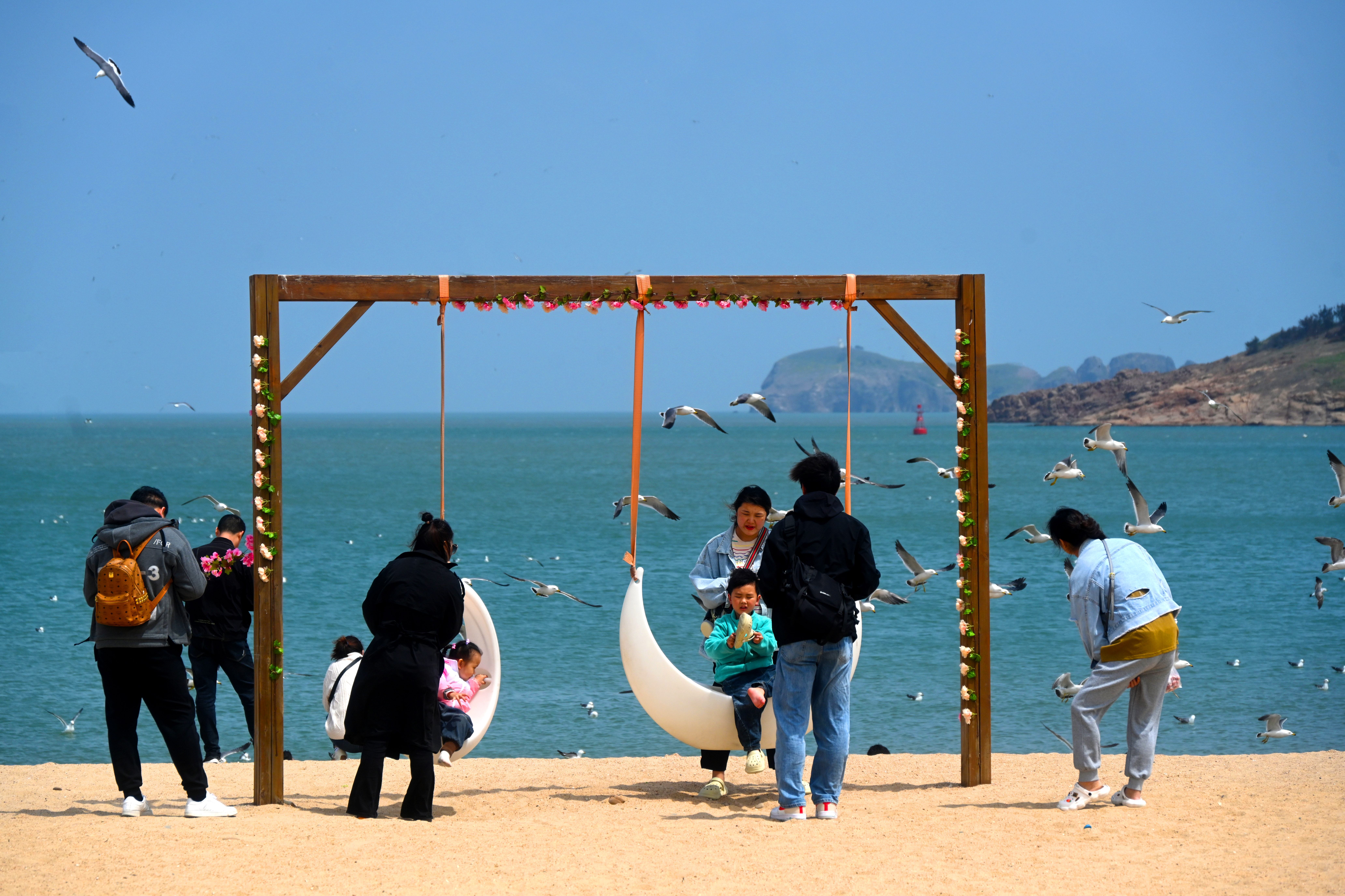 Tourists enjoy themselves along the beach on Hailyu Island in Weihai, Shandong on May 3, 2023. /CFP 