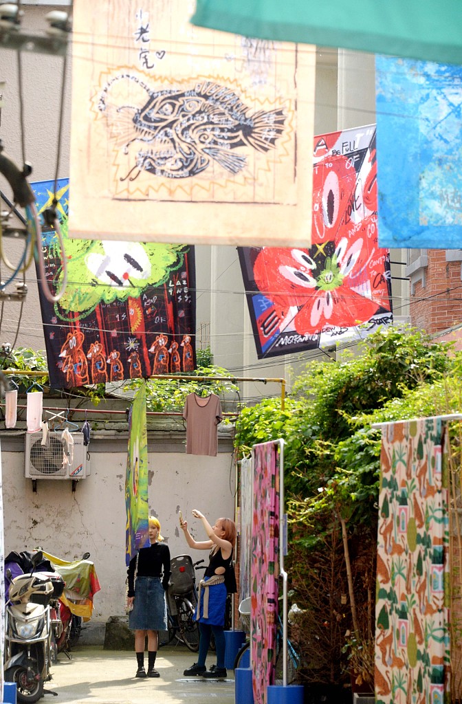 Shanghai residents admire a new bed sheet art exhibition taking place in the city's old alleys. /CFP