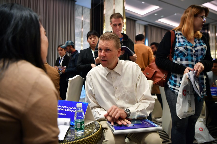 A foreign job hunter communicates with an employer during a job fair in Haikou, south China's Hainan Province, December 18, 2019. /Xinhua