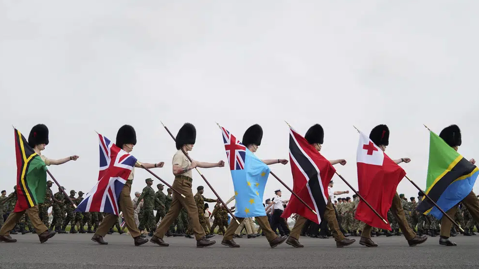 Guards carry flags from Commonwealth countries during a full tri-service and Commonwealth rehearsal at RAF Odiham in Hook, England, April 30, 2023, ahead of their involvement in the second procession that accompanies King Charles III and Queen Camilla from Westminster Abbey back to Buckingham Palace./AP
