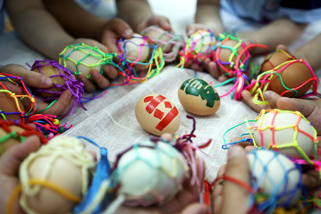 Kids in Changzhou, Jiangsu Province display colorful handmade egg pouches on May 5, 2023 to celebrate the Lixia solar term. /CFP