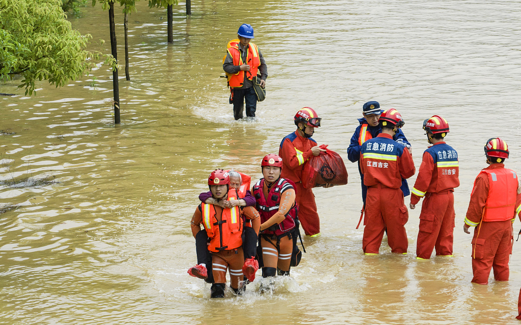 A rescue team of firefighters evacuate residents trapped by flood in a village in Ji'an City, east China's Jiangxi Province, May 6, 2023. /CFP