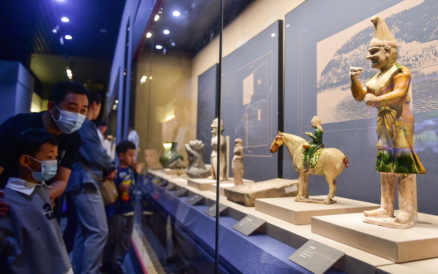 Visitors browse through cultural relics at an exhibition based on the theme of eight Chinese capitals at Luoyang Museum in central China's Henan, on May 7, 2023. /CNSPHOTO