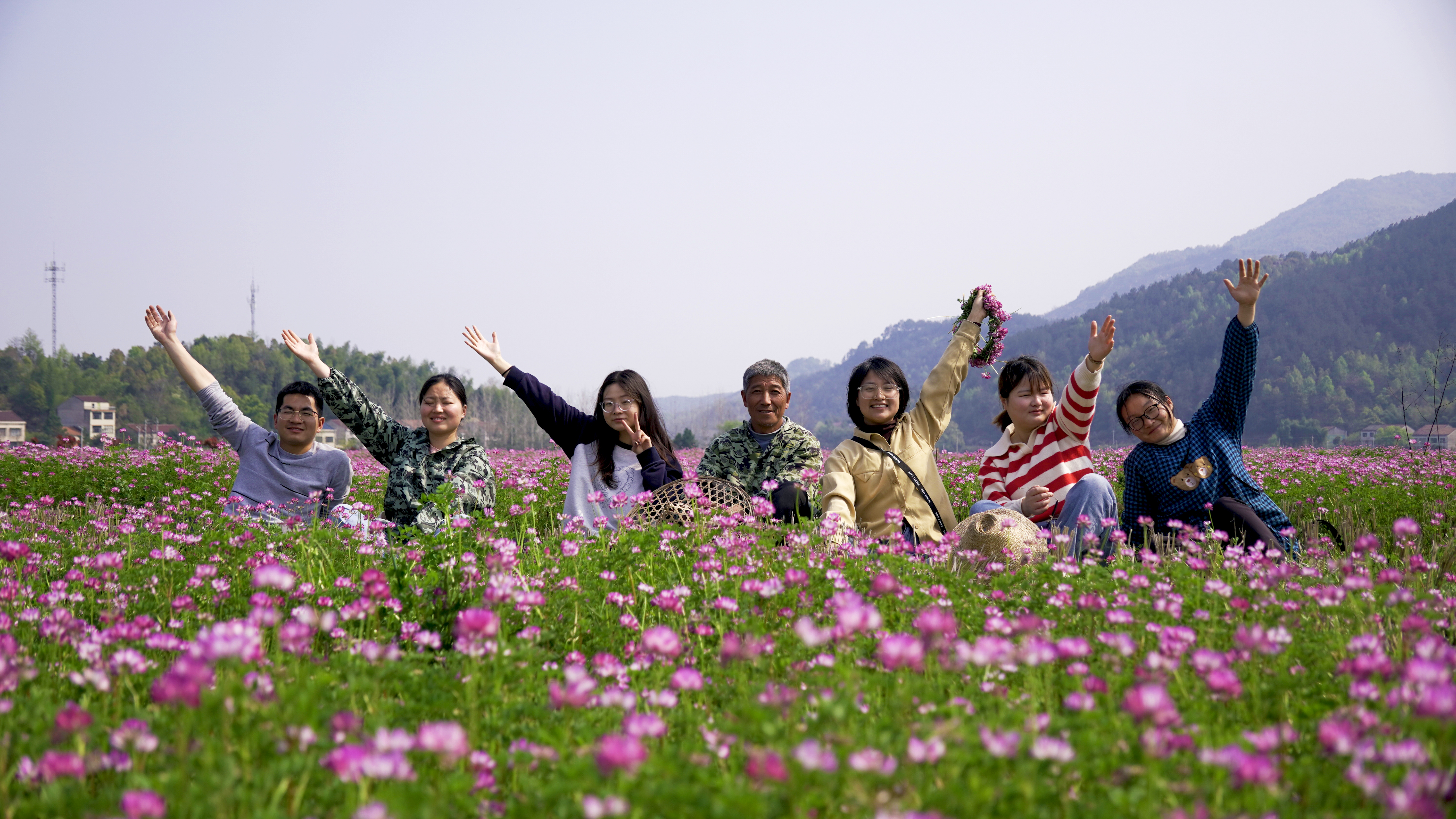 Employees of Qianyi Agriculture at Damiao production base in Huanggang City, central China's Hubei Province, April, 2023. They are in a field of Chinese milkvetch, which is commonly used in farming as a green manure. /Courtesy of Li Mingpan