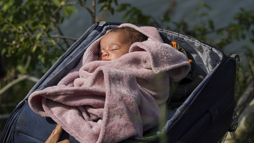 Migrants cross the Rio Grande river with a baby in a suitcase, as seen from Matamoros, Mexico, May 10, 2023. /CFP