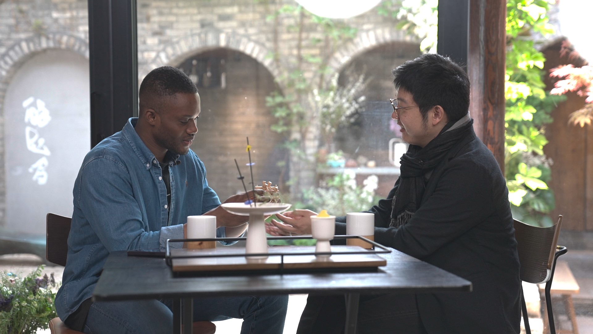 A still shows Michael Harford (left) chatting with Hai Peng, a courtyard designer, in Beijing. /CMG 