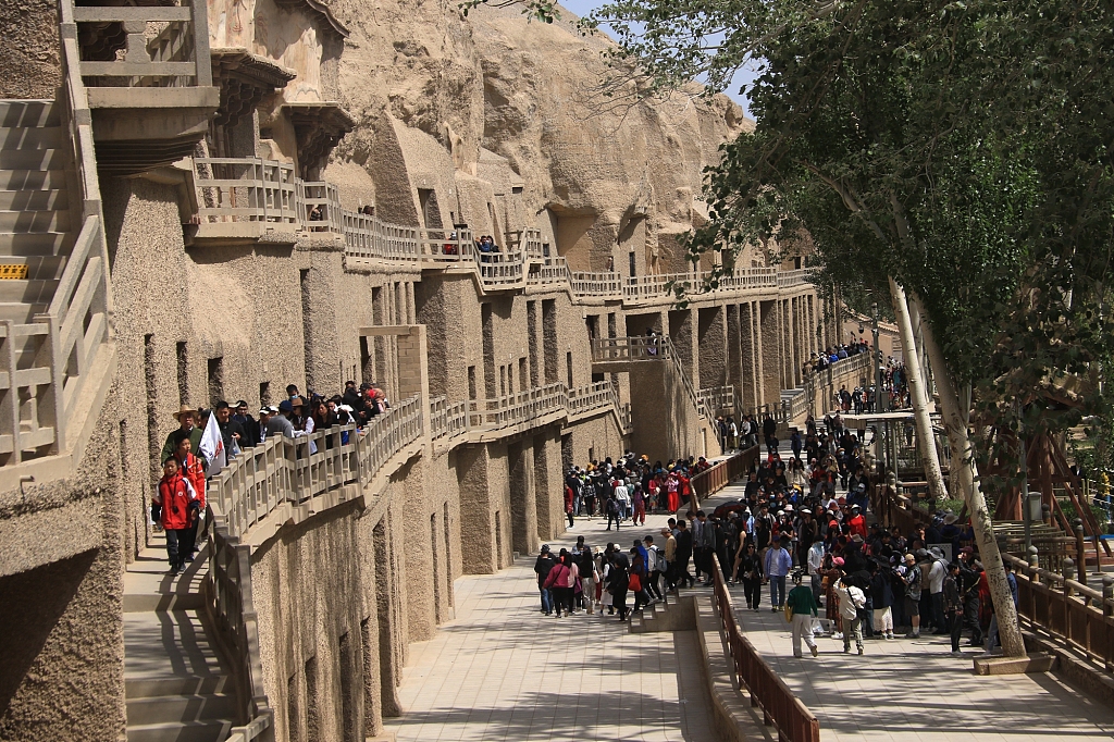 Tourists visit the Mogao Caves in Dunhuang City, Gansu Province, China, on May 11, 2023. /CFP