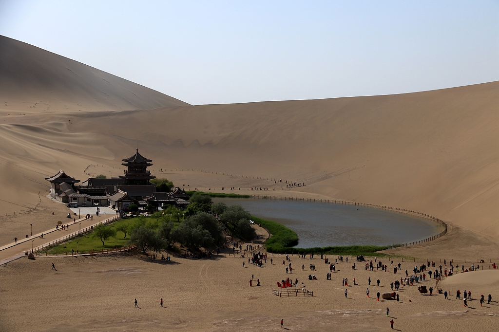 Tourists visit the Crescent Lake Scenic Area at Mingsha Mountain in Dunhuang City, Gansu Province, China, on May 11, 2023. /CFP