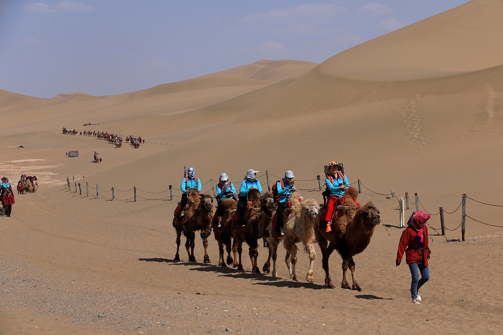 Tourists visit the Crescent Lake Scenic Area at Mingsha Mountain in Dunhuang City, Gansu Province, China, on May 11, 2023. /CFP