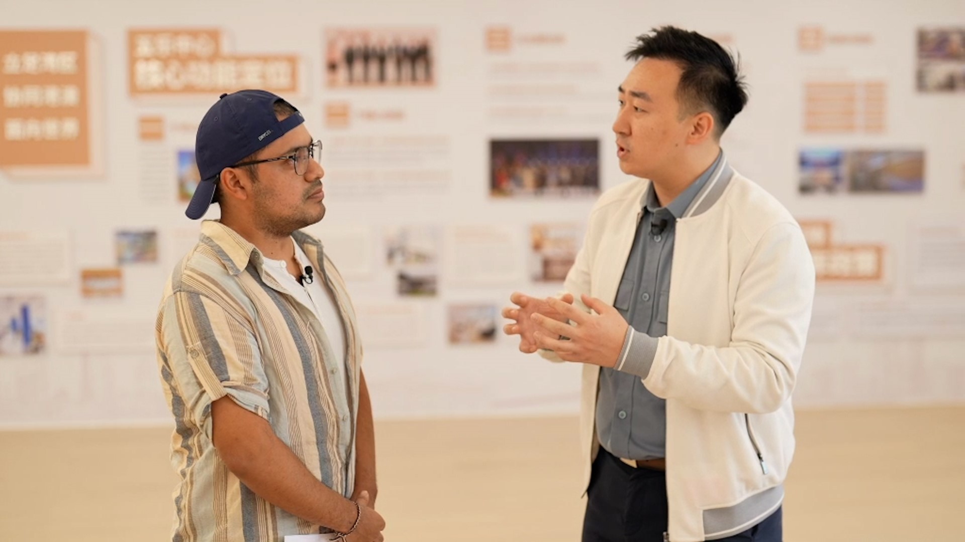 Zhang Ruimo (left) from Mexico talks with Sun Hongrui at the Hong Kong and Macao Youth Wule Service Center in Guangzhou, south China's Guangdong Province. /CMG 