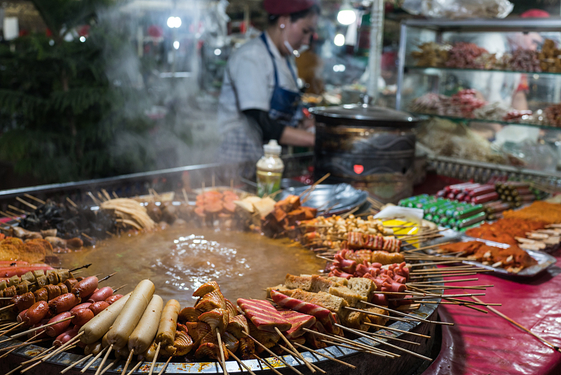 A vendor is busy preparing street food in Kashgar Prefecture, Xinjiang. /CFP