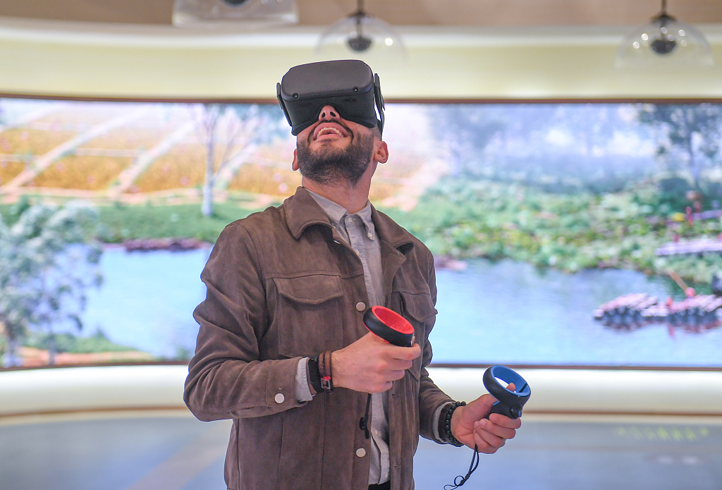 A foreign visitor gives the 5G+VR experience a try at the Archaeological Ruins of Liangzhu City in Hangzhou, Zhejiang, on May 5, 2021. /CFP
