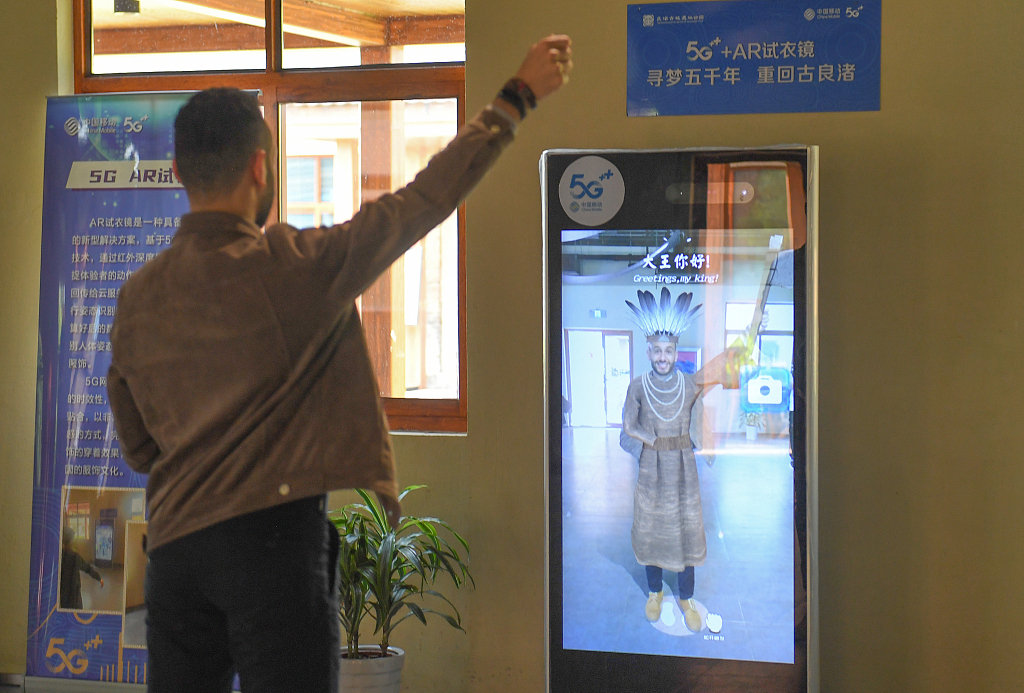A foreign visitor tries out a 5G+AR dressing up mirror at the Archaeological Ruins of Liangzhu City in Hangzhou, Zhejiang, on May 5, 2021. /CFP