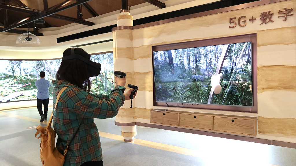 With a VR headset and two game controllers, a tourist tries a deer hunting experience that replicates how the ancient Liangzhu residents used to stalk animals at the Archaeological Ruins of Liangzhu City in Hangzhou, Zhejiang, on May 2, 2021. /CFP