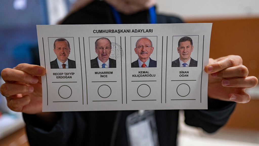 A person holds ballot papers showing Turkish presidential candidates Recep Tayyip Erdogan, Muharrem Ince, Kemal Kilicdaroglu and Sinan Ogan at a polling station in Istanbul,Türkiye, May 14, 2023./CFP