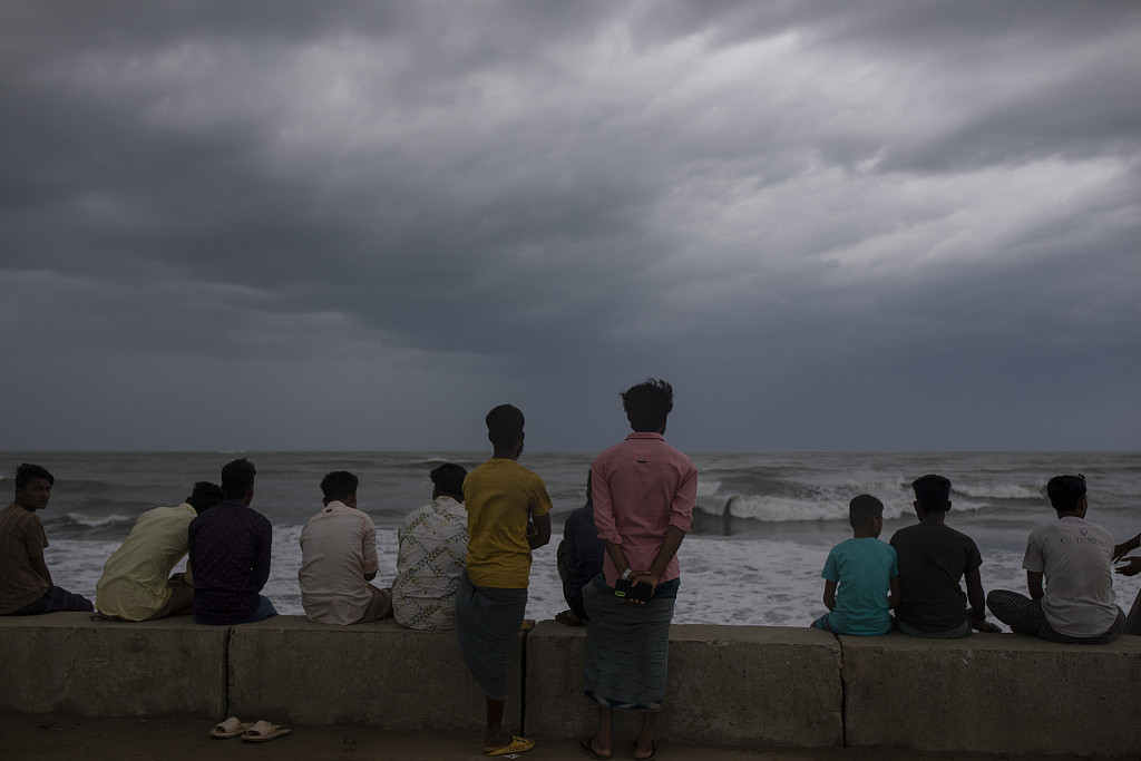 People gather at Shahpori island beach in Teknaf, Bangladesh, ahead of Cyclone Mocha's landfall on May 13, 2023. /VCG