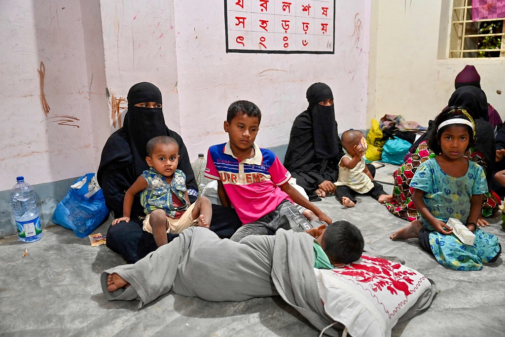 Women take shelter with their children in Shahpori island on the outskirts of Teknaf, Bangladesh, on May 13, 2023, ahead of Cyclone Mocha's landfall. Tens of thousands of residents were evacuated on May 13 in Bangladesh and neighboring Myanmar. /VCG