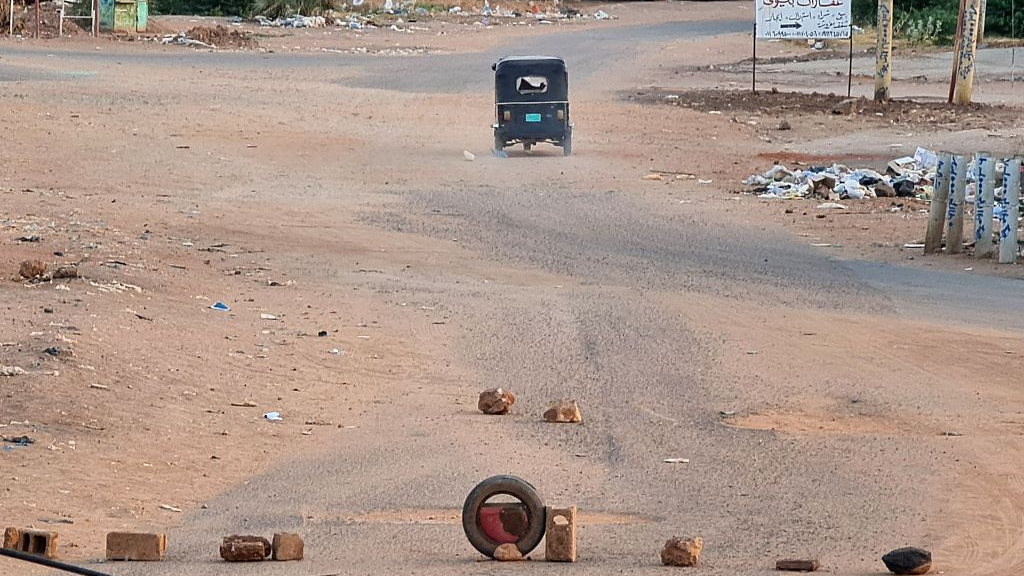 A tuk-tuk drives away from a blocked road in war-torn Khartoum, Sudan, May 14, 2023. /CFP