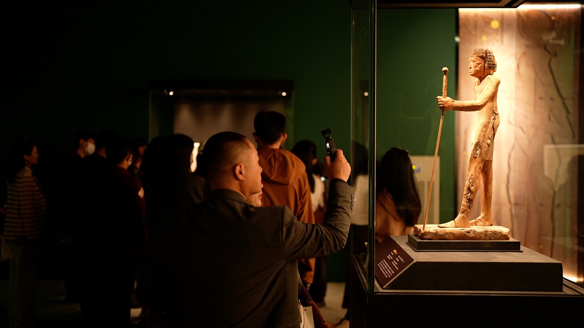 Visitors take pictures of the artifacts on display in Beijing. /CGTN