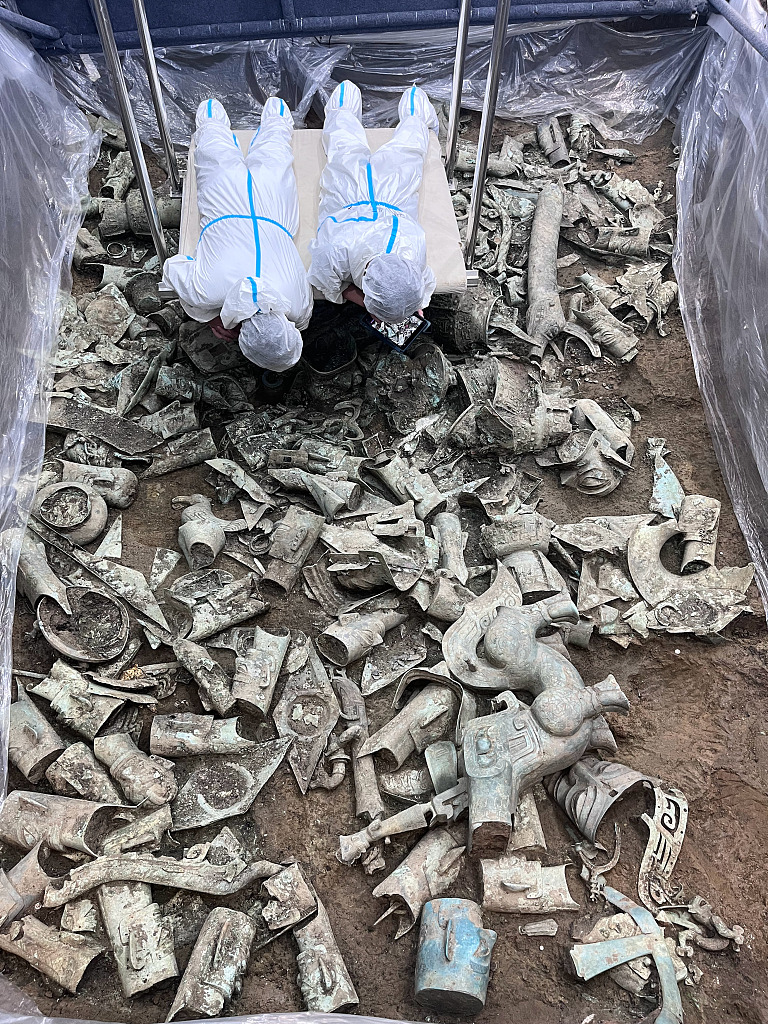 Archeologists work at the No. 8 sacrificial pit of the Sanxingdui ruin site on July 5, 2022. As the biggest sacrificial pit discovered so far, No. 8 pit is where the most cultural artifacts have been unearthed, including gold masks, bronze statues, ivory artifacts, and a bronze altar, among other large items. /CFP