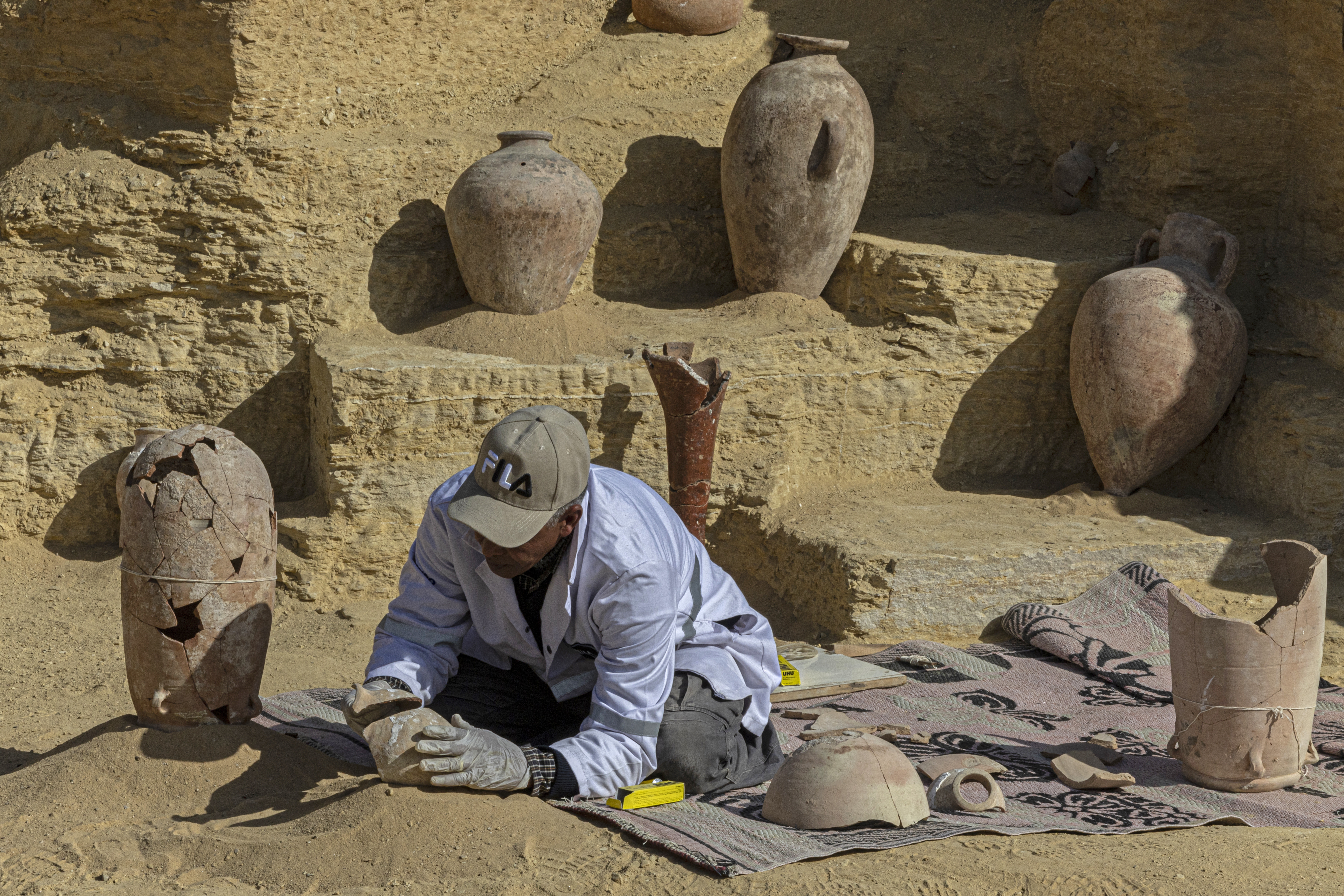 An Egyptian archaeologist restores antiquities at the Saqqara archaeological site, south of Cairo on January 26, 2023. /AFP